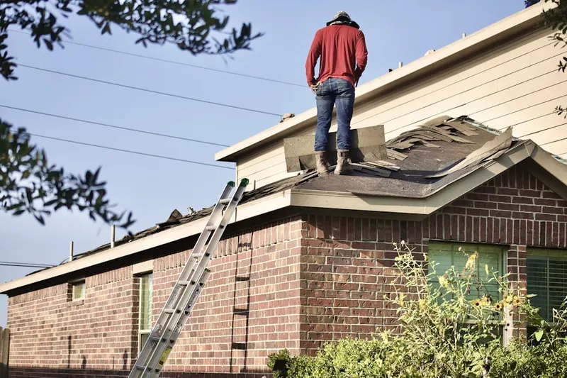 Professional roofer working on a residential roof in Cromwell Hills